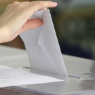 Una mujer introduce una papeleta de voto en una urna, en una imagen de archivo.-ICAL.
