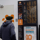 Un hombre observando los precios del carburante el día de la bajada de 20 céntimos por litro.- PHOTOGENIC