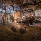 Un espeleólogo contempla la Sala del Cacique, por la que pasan los visitantes de Cueva Palomera. Abajo, acceso a la ermita de San Bernabé.