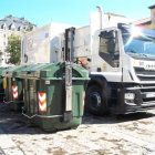 Un camión de basura al lado de unos contenedores en León.