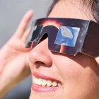 Una mujer observa a través de las gafas de eclipse