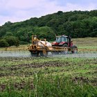 Un agricultor rocía un fertilizante en un campo de cultivo.